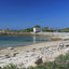 Photo from Friendly Guides Isles of Scilly Guidebook showing people sitting on the beach at Great Par near the Hell Bay Hotel on Bryher, Isles of Scilly.