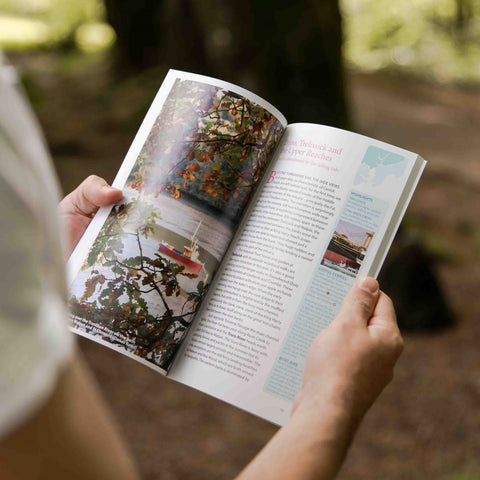 Holding the Falmouth and Roseland Guidebook which shows a picture of the Fal Estuary and the start of a chapter about Trelissick