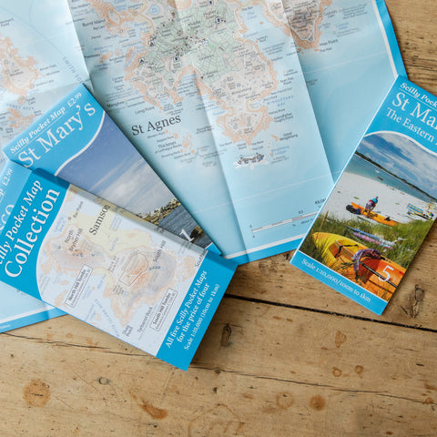 a photo of a folded map of St Agnes Isles of Scilly spread out on a wood table