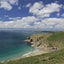 Photo from Friendly Guides Lizard Guidebook of Rinsey (Porthcew) Cove with Mount's Bay in the background. West Cornwall.