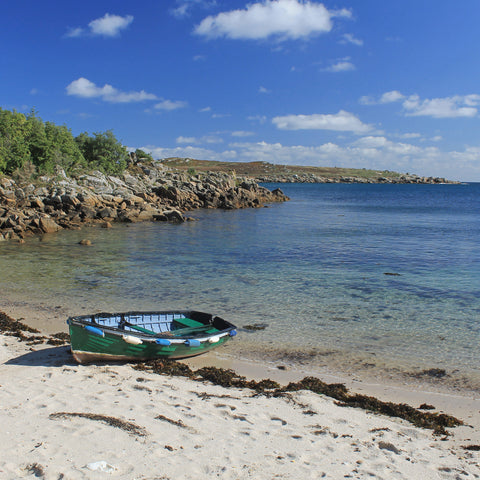 Photo from Friendly Guides Isles of Scilly Guidebook showing boat at Cove Vean on St Agnes, Isles of Scilly. In the background is Gugh.