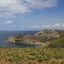 Photo from Friendly Guides Isles of Scilly Guidebook looking over Burnt Hill to Chapel Down Daymark at St Martin's Head on the Isles of Scilly. Land's End is in the far distance.